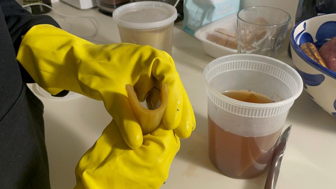 A person wearing yellow gloves