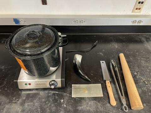 A pot on a stove with utensils on it