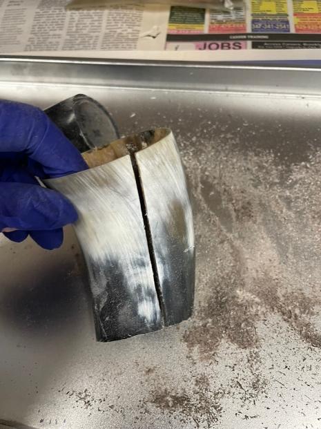 A hand in glove holding a horn