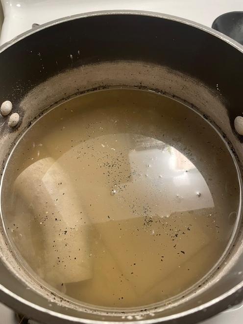 A bowl of liquid with a few small white balls